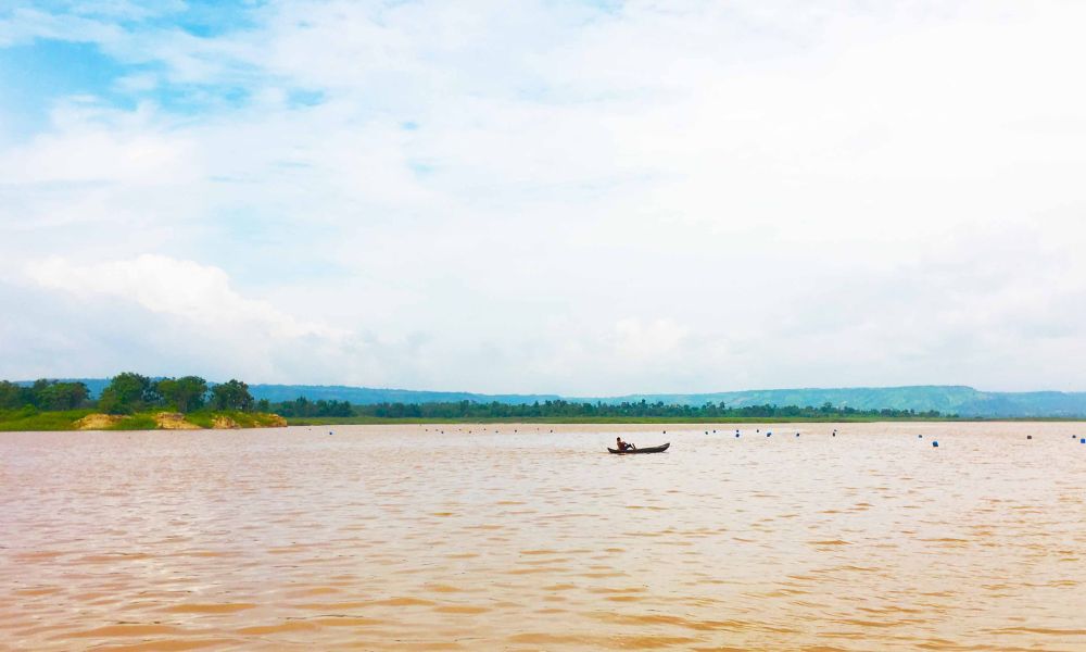 Một chiếc thuyền nhỏ trên mặt nước rộng tạo cảm giác yên, hợp với ảnh chiều hoặc ảnh tối giản.